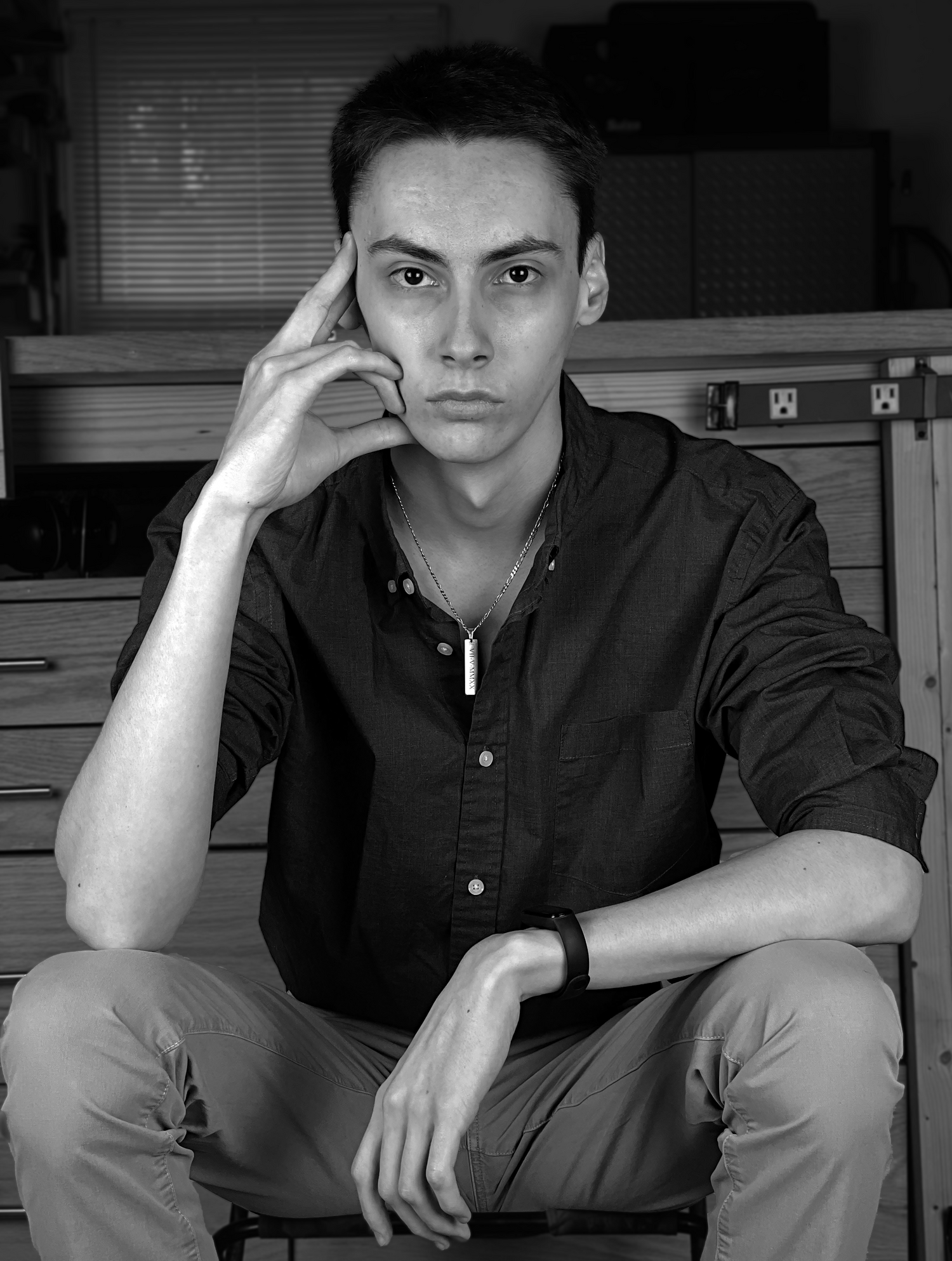 Logan Prichard sitting in front of his workbench with a serious look on his face.